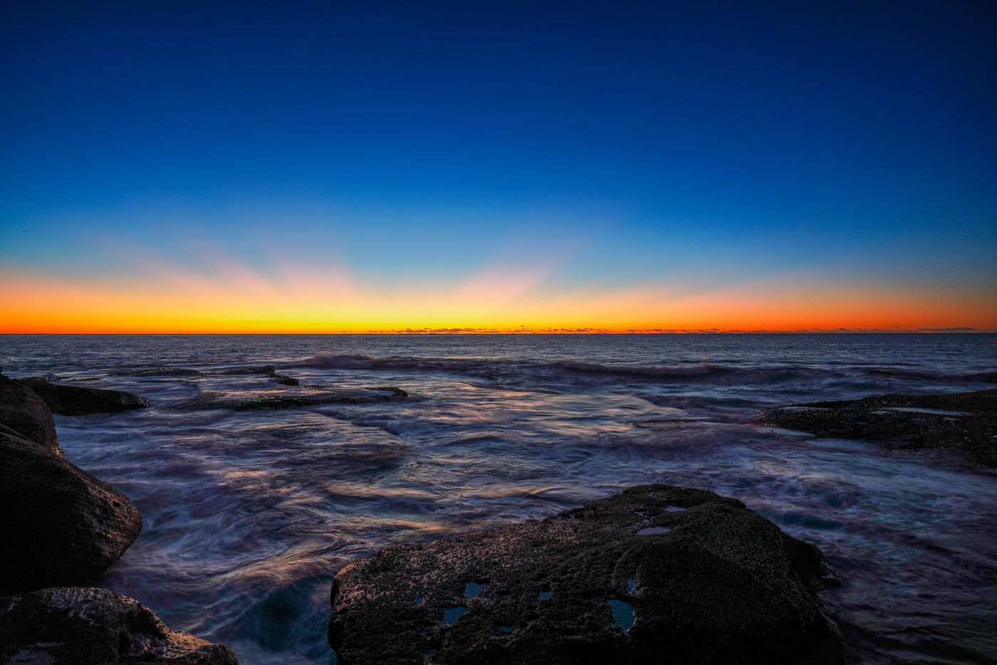 Pre-dawn long exposure with silky water over the rock shelf