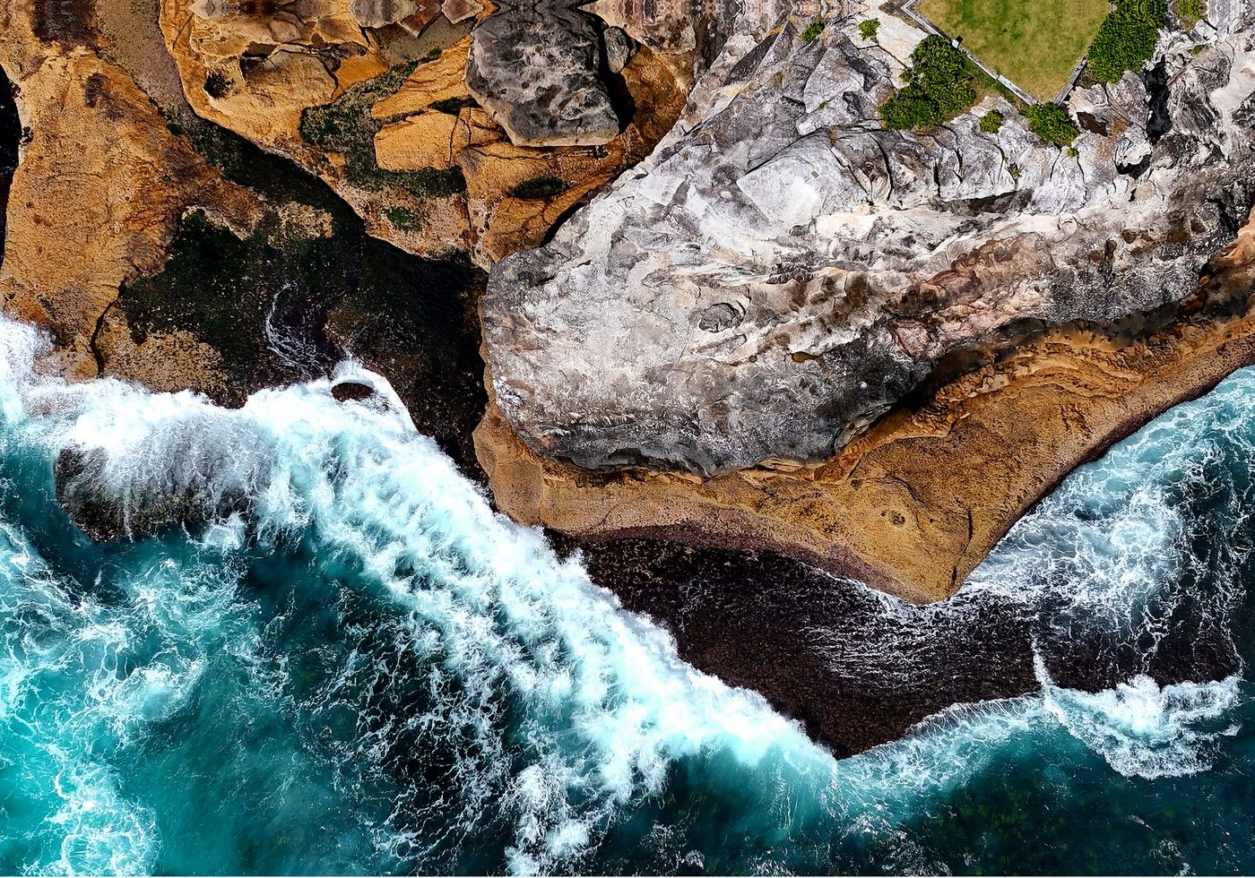 Top-down drone view of cliffs and turquoise whitewater